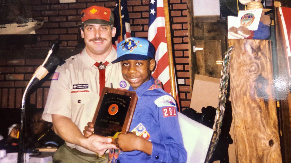 A young Justin receives a Distinguished Community Service Award with Cub Pack 281 in Brooklyn